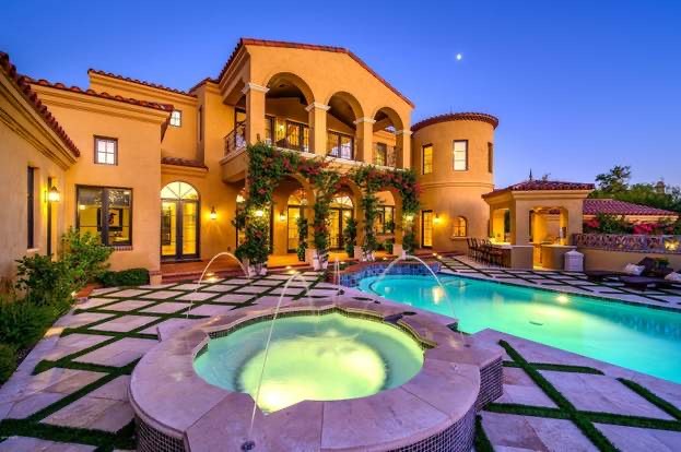 Luxury backyard with pool, water features, custom pavers, trees, and manicured lawn